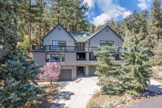 2405 Cedarwood Dr, Pine Mountain Club, CA 93222 - chalet / cabin featuring a balcony, an attached garage, stone siding, and driveway