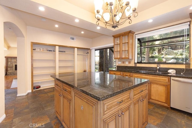 kitchen featuring visible vents, arched walkways, a sink, stone tile flooring, and dishwashing machine