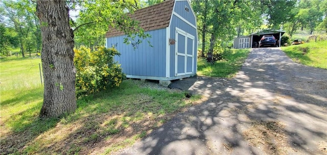 16937 Stagecoach Rd, Corning, CA 96021 - view of property exterior with driveway, a storage unit, a detached carport, an outbuilding, and roof with shingles