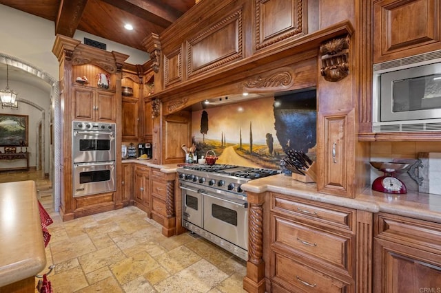 6314 El Apajo, Rancho Santa Fe, CA 92067 - kitchen featuring appliances with stainless steel finishes, stone tile flooring, light countertops, brown cabinetry, and recessed lighting