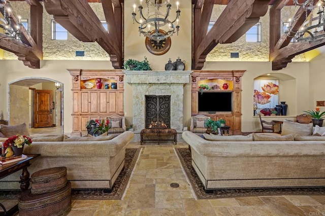 6314 El Apajo, Rancho Santa Fe, CA 92067 - living room featuring a towering ceiling, stone tile floors, arched walkways, a chandelier, and a high end fireplace