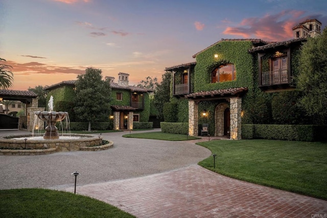 6314 El Apajo, Rancho Santa Fe, CA 92067 - mediterranean / spanish-style home featuring curved driveway, a balcony, a front lawn, a tile roof, and stone siding