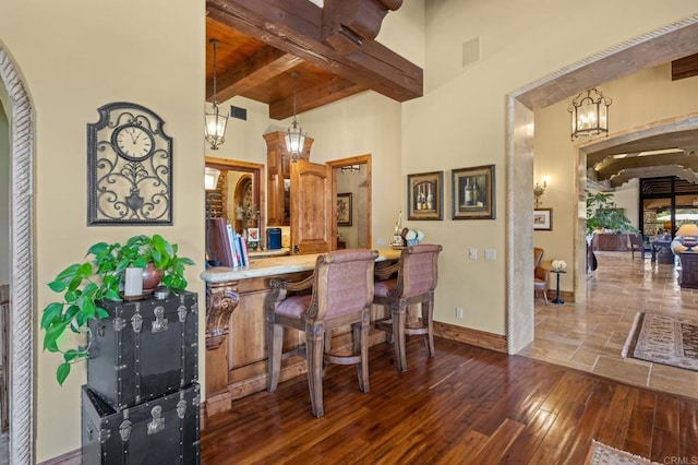 6314 El Apajo, Rancho Santa Fe, CA 92067 - dining space featuring a chandelier, wood-type flooring, a towering ceiling, and a wooden ceiling with exposed beams