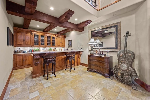 6314 El Apajo, Rancho Santa Fe, CA 92067 - indoor wet bar with stone tile floors, beamed ceiling, coffered ceiling, tasteful backsplash, and recessed lighting