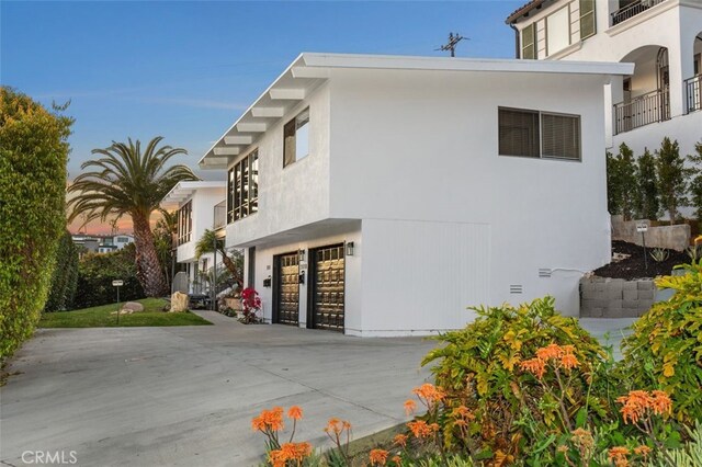 2516 Bayside Dr, Corona Del Mar, CA 92625 - view of side of property with driveway, a garage, and stucco siding