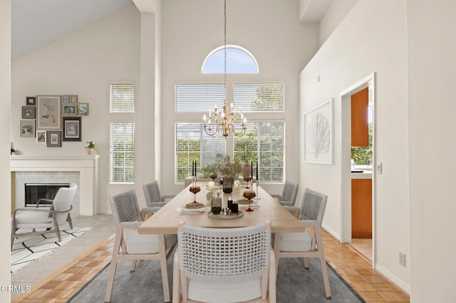 2101 Fox Den Ct, Oxnard, CA 93036 - dining space with high vaulted ceiling, baseboards, an inviting chandelier, and a premium fireplace