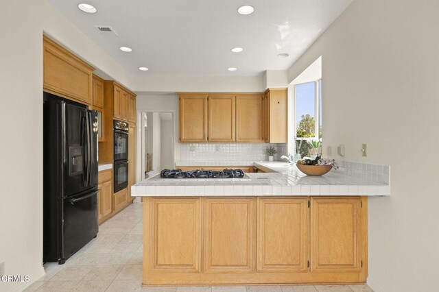 2101 Fox Den Ct, Oxnard, CA 93036 - kitchen featuring tasteful backsplash, recessed lighting, a peninsula, light tile patterned flooring, and black appliances