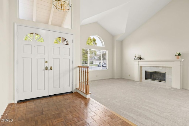 2101 Fox Den Ct, Oxnard, CA 93036 - foyer with high vaulted ceiling, a fireplace, carpet, a chandelier, and baseboards