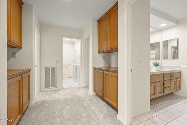 2101 Fox Den Ct, Oxnard, CA 93036 - hall featuring a sink, visible vents, washer / clothes dryer, and light tile patterned floors