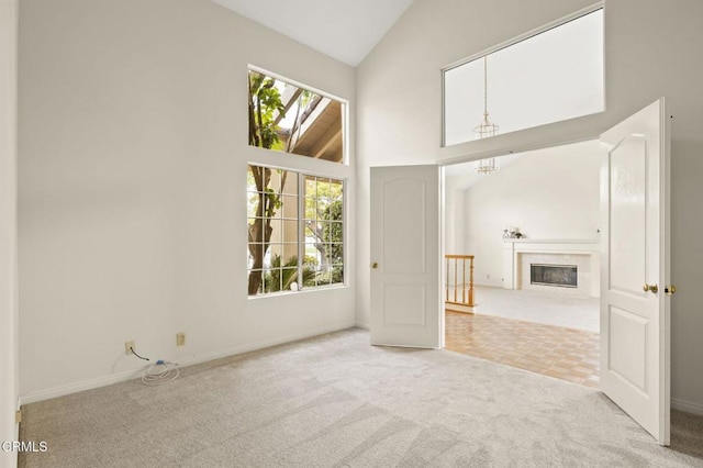 2101 Fox Den Ct, Oxnard, CA 93036 - unfurnished living room featuring baseboards, a notable chandelier, carpet, a fireplace, and high vaulted ceiling