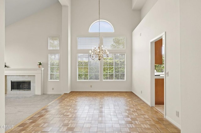 2101 Fox Den Ct, Oxnard, CA 93036 - unfurnished living room with high vaulted ceiling, a tile fireplace, baseboards, and a chandelier