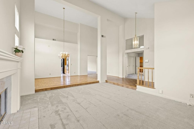2101 Fox Den Ct, Oxnard, CA 93036 - unfurnished living room featuring a notable chandelier, a fireplace, visible vents, high vaulted ceiling, and carpet