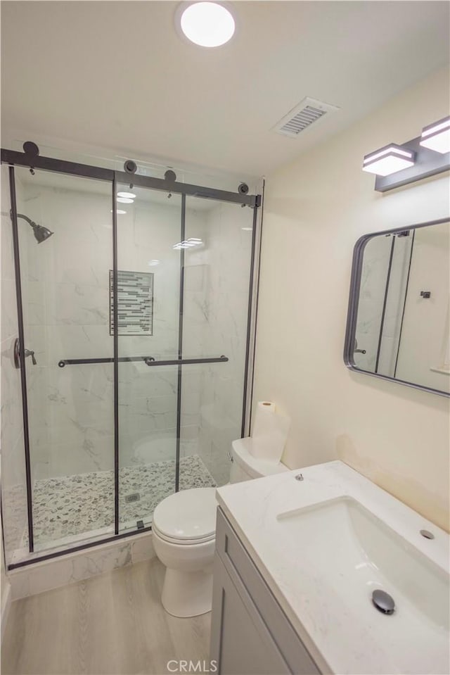 3456 Crownsworth St, Corona, CA 92879 - bathroom with visible vents, wood finished floors, a marble finish shower, and toilet