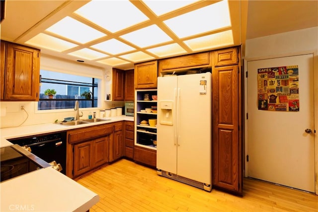 kitchen featuring a sink, white refrigerator with ice dispenser, and brown cabinetry
