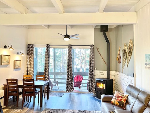 24 Tyrol Ln Unit 103, Mammoth Lakes, CA 95346 - dining space featuring a wood stove, wood finished floors, beamed ceiling, and a ceiling fan
