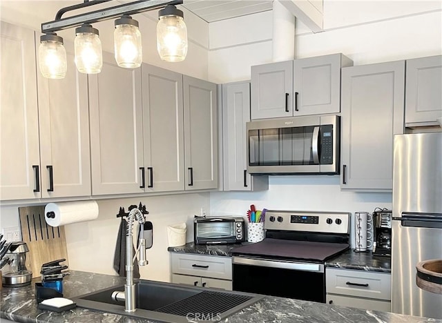 24 Tyrol Ln Unit 103, Mammoth Lakes, CA 95346 - kitchen with appliances with stainless steel finishes, dark stone counters, and gray cabinets