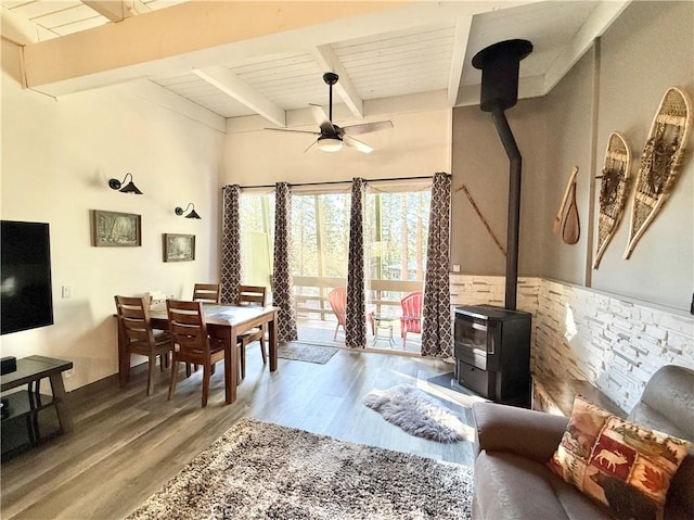 24 Tyrol Ln Unit 103, Mammoth Lakes, CA 95346 - dining area featuring a wood stove, wood finished floors, ceiling fan, and a wood ceiling with exposed beams