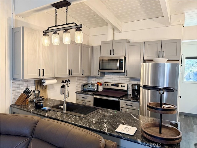 24 Tyrol Ln Unit 103, Mammoth Lakes, CA 95346 - kitchen featuring appliances with stainless steel finishes, dark stone counters, decorative backsplash, beamed ceiling, and dark wood-style floors
