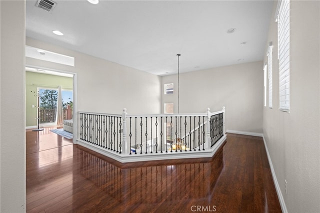 8481 Attica Dr, Riverside, CA 92508 - hallway with wood-type flooring, visible vents, baseboards, and an upstairs landing