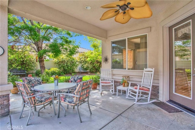 view of patio / terrace with outdoor dining space, ceiling fan, and fence