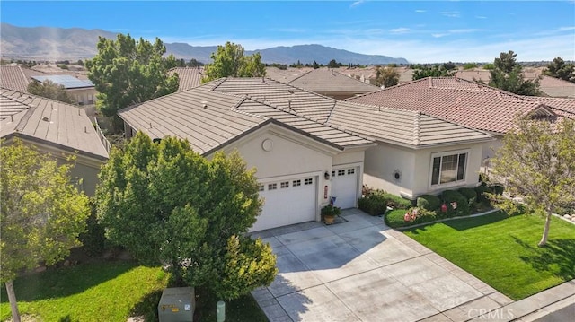 view of front of home featuring a front lawn, driveway, a tiled roof, a garage, and stucco siding
