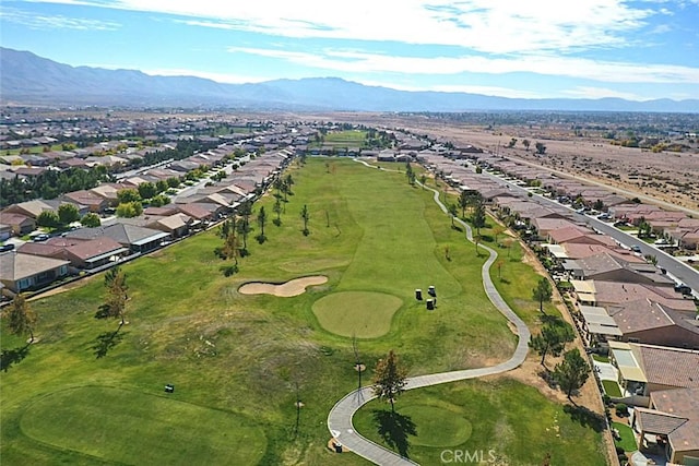 drone / aerial view with view of golf course, a mountain view, and a residential view
