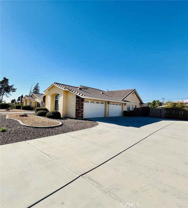 19640 Yanan Rd, Apple Valley, CA 92307 - ranch-style house featuring a garage, stucco siding, a tile roof, fence, and driveway