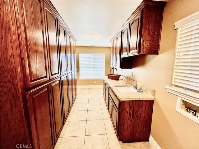 19640 Yanan Rd, Apple Valley, CA 92307 - laundry area with a sink, cabinet space, light tile patterned flooring, washer hookup, and baseboards
