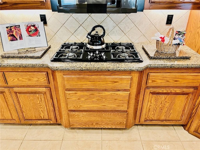 19640 Yanan Rd, Apple Valley, CA 92307 - kitchen with black gas cooktop, tasteful backsplash, light tile patterned floors, and brown cabinets
