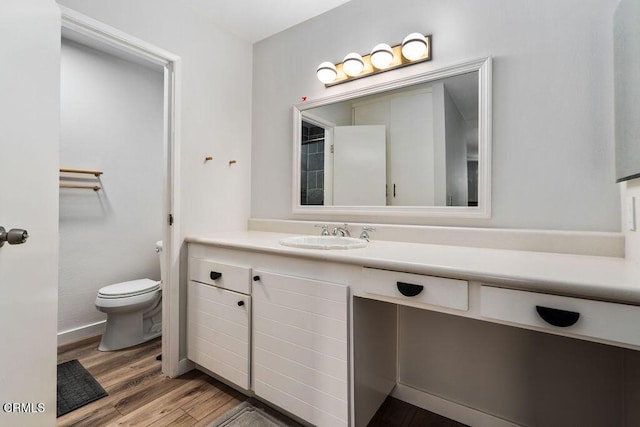 bathroom featuring vanity, wood finished floors, and toilet