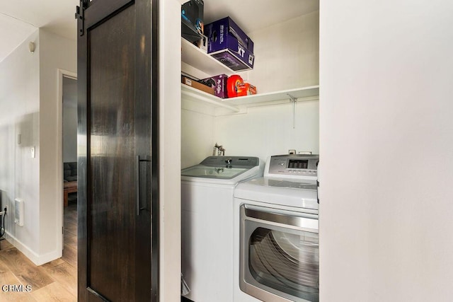 laundry area featuring laundry area, light wood finished floors, and washer and dryer