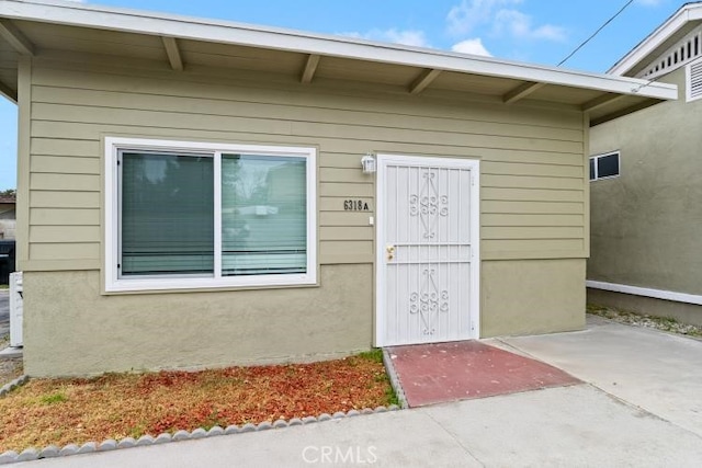 view of exterior entry with stucco siding