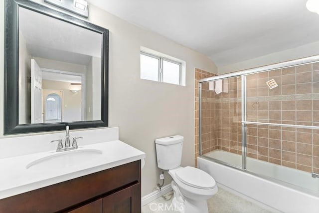 bathroom featuring toilet, vanity, bath / shower combo with glass door, and baseboards