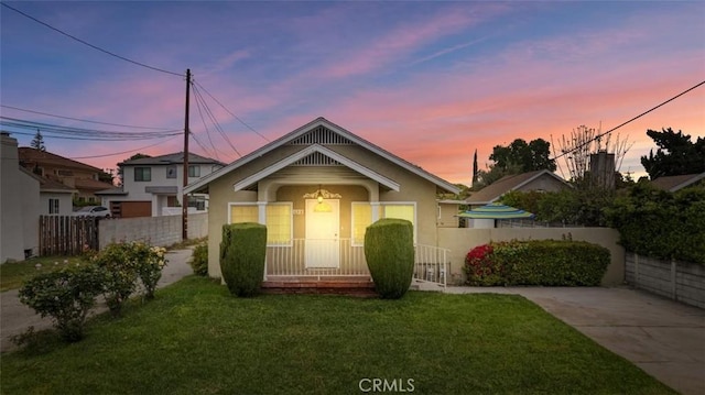 bungalow-style home featuring stucco siding, fence private yard, and a front yard
