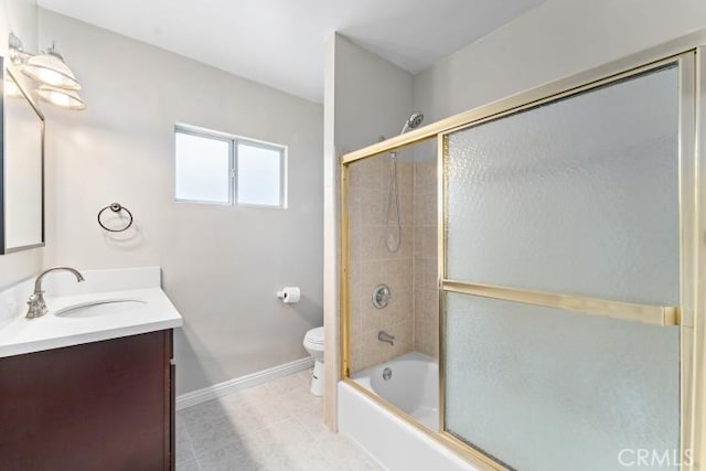 bathroom with tile patterned flooring, enclosed tub / shower combo, toilet, vanity, and baseboards