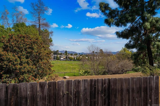 view of yard with a mountain view and fence