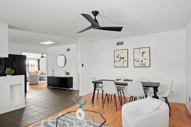 dining space with baseboards, a ceiling fan, and visible vents