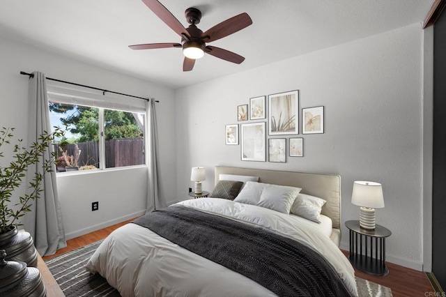 bedroom with baseboards, ceiling fan, and wood finished floors