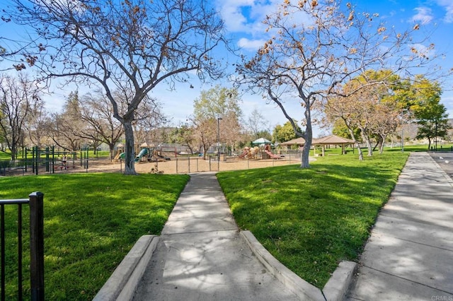 surrounding community featuring playground community, fence, and a lawn