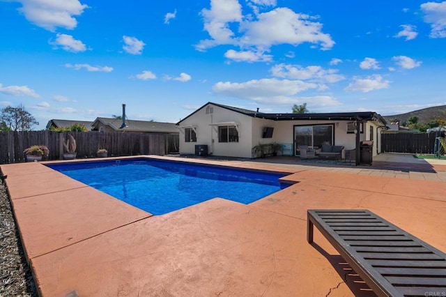 view of swimming pool with cooling unit, a fenced backyard, a fenced in pool, and a patio area