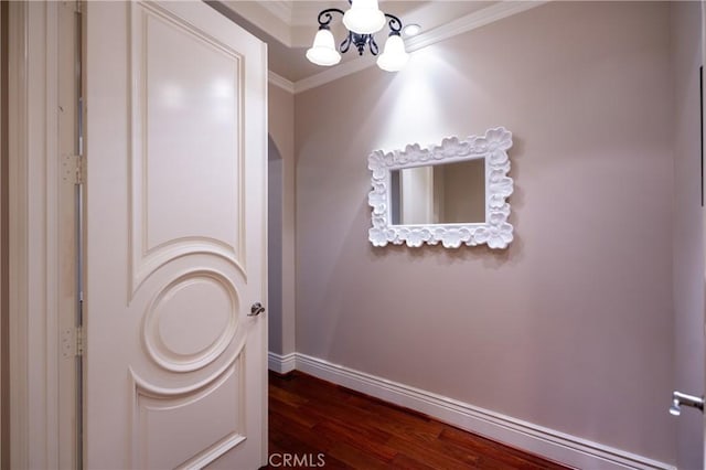 bathroom with wood finished floors, crown molding, baseboards, and a notable chandelier