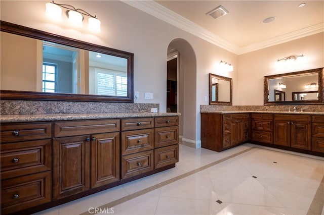bathroom with tile patterned floors, visible vents, vanity, ornamental molding, and baseboards
