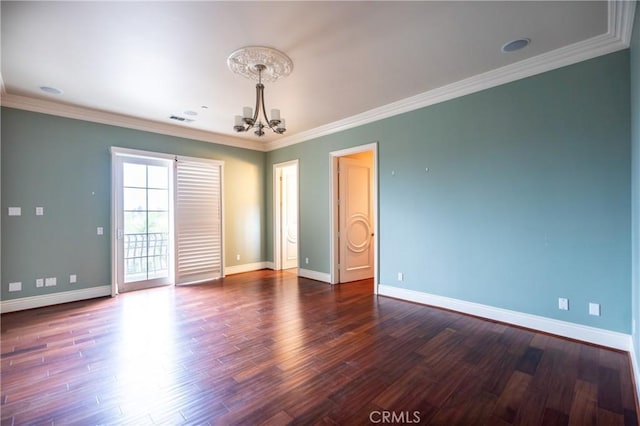 spare room featuring dark wood finished floors, visible vents, ornamental molding, baseboards, and a notable chandelier