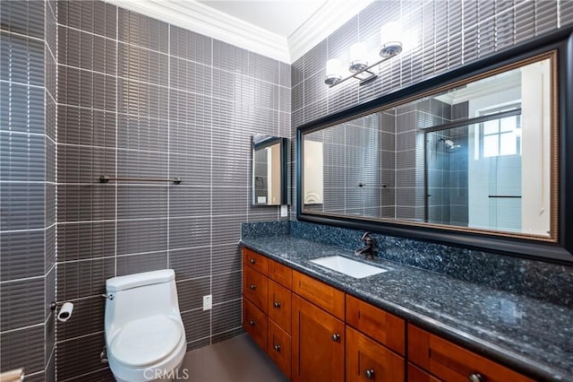 bathroom with toilet, tile walls, tiled shower, vanity, and ornamental molding