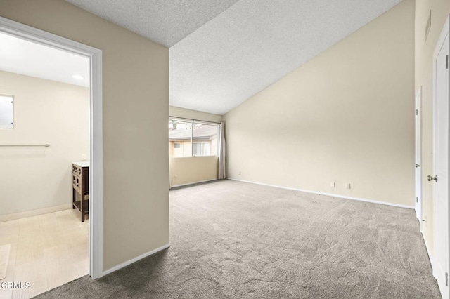 spare room with a textured ceiling, baseboards, and carpet floors