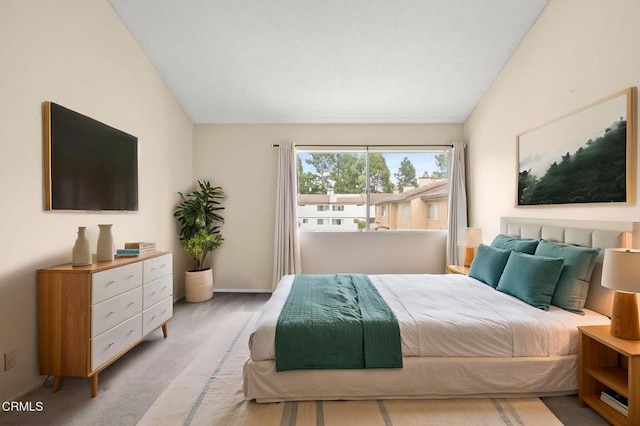 bedroom featuring light colored carpet and lofted ceiling