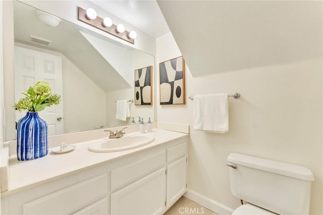 bathroom featuring vaulted ceiling, visible vents, toilet, vanity, and baseboards