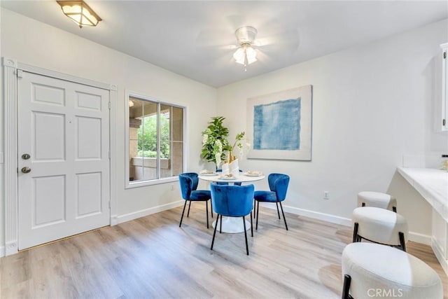 dining room with baseboards, a ceiling fan, and light wood-style floors