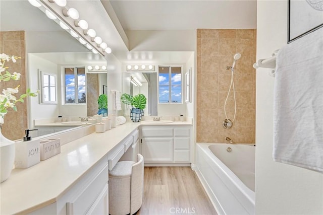 full bath featuring wood finished floors, vanity, and bathtub / shower combination