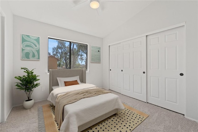carpeted bedroom featuring a closet, baseboards, a ceiling fan, and lofted ceiling